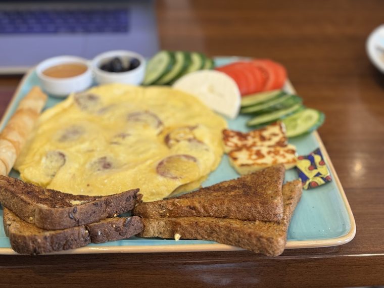 A Turkish-style breakfast omelette platter with halloumi, cucumber, tomato, olives, honey and toasted bread